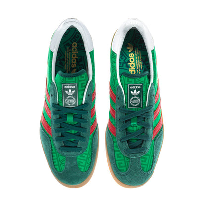 Green men's indoor sneakers with white tongues and red three-stripe detailing.