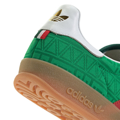 Green upper with white heel and adidas logo on gum sole of men's indoor sneakers.