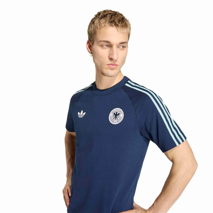 Men's navy tee with white trefoil logo and circular crest, raglan sleeves with stripes.