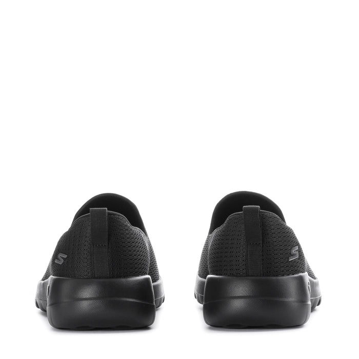 Women's black slip-on walking shoes, heel view with logo detail on back
