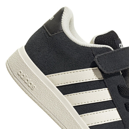 Black toddler sneaker close-up, white stripes and Velcro strap on cuff