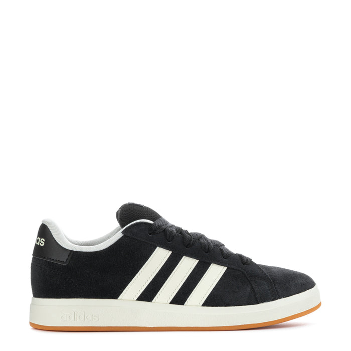 Black Adidas sneakers with white three stripes and gum outsole, side view.