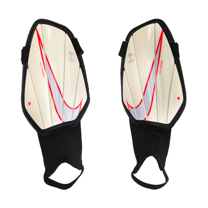 Youth shin guards with black shell and beige interior, red logo accents, pair