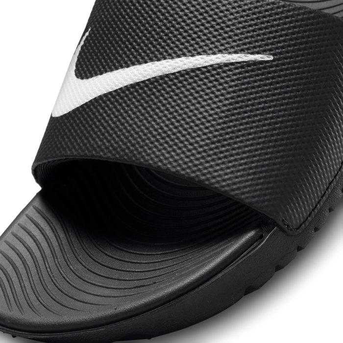Youth black slide sandal strap close-up with white Nike swoosh and textured grip