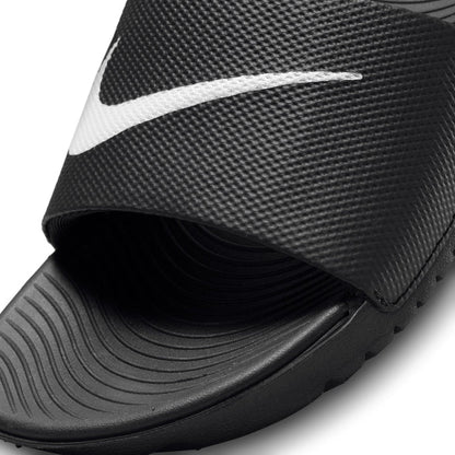 Youth black slide sandal strap close-up with white Nike swoosh and textured grip