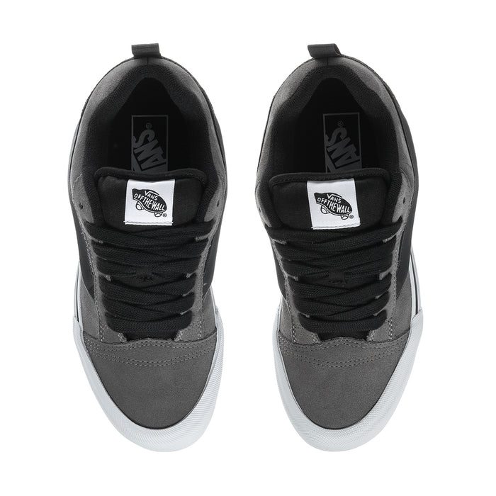 Men's sneaker tongue and collar with black laces and brand patch on pewter suede