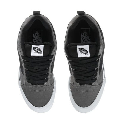 Men's sneaker tongue and collar with black laces and brand patch on pewter suede