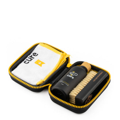 Sneaker cleaning kit in black case with brush, black bottle, and white-yellow cloth