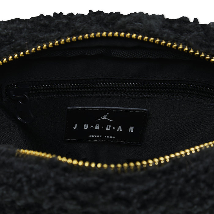 Black interior pocket with leather brand label and gold zipper on sherpa camera bag