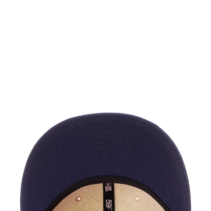 Navy baseball cap brim close-up with stitched edge and small interior label