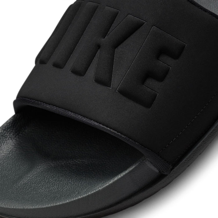 Women's black slide sandal close-up with embossed NIKE lettering on strap