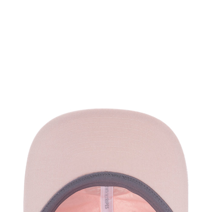 Light pink strapback cap showing inner opening and side tag near brim