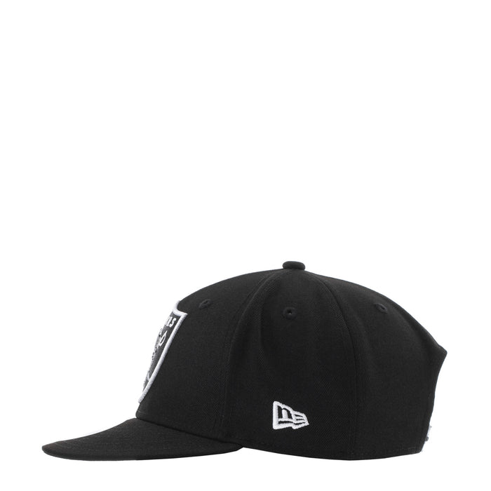 Black snapback cap with small white Raiders logo patch on the front