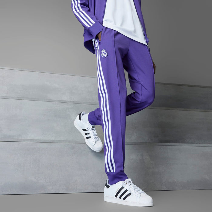 Men's purple track pants with triple white stripes and drawstring waist; side view