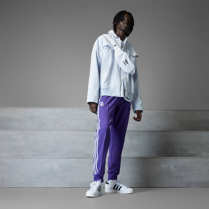 Purple track pants with white side stripes, taper legs, and ribbed cuffs