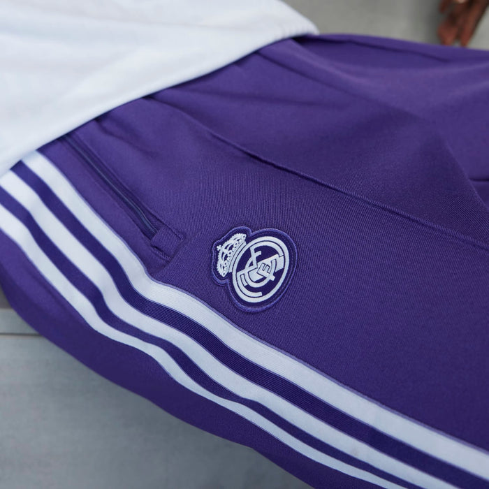 Purple track pants detail: club crest badge and white triple stripe