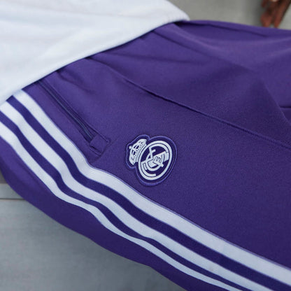 Purple track pants detail: club crest badge and white triple stripe