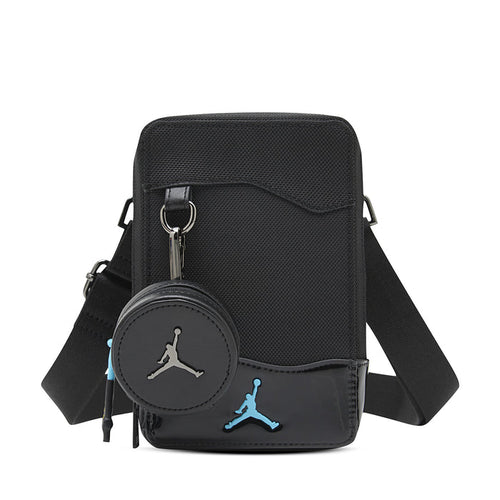 Black crossbody bag with zip top, front flap, and blue Jumpman logo patch