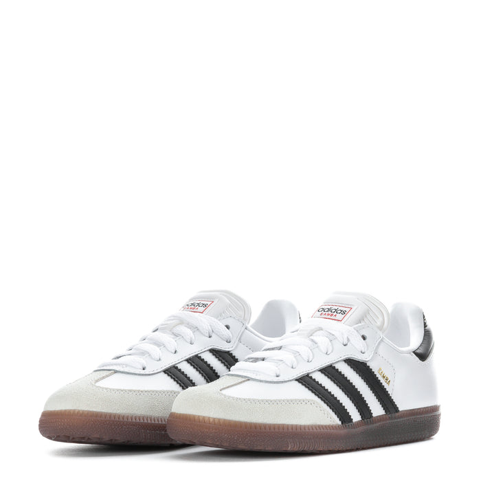 Pair of kids white sneakers with black side stripes and gum-brown rubber sole
