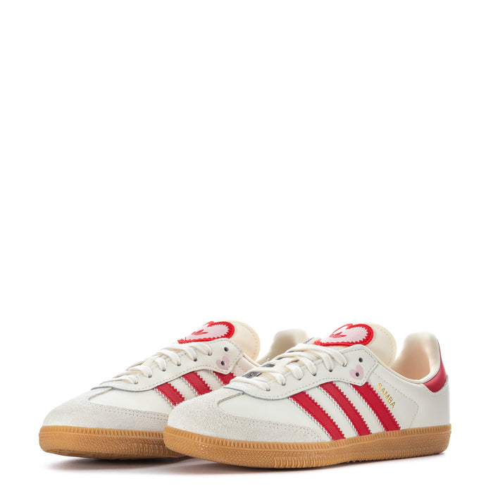 Kids pair of cream sneakers with red accents, lace-up with gum rubber sole