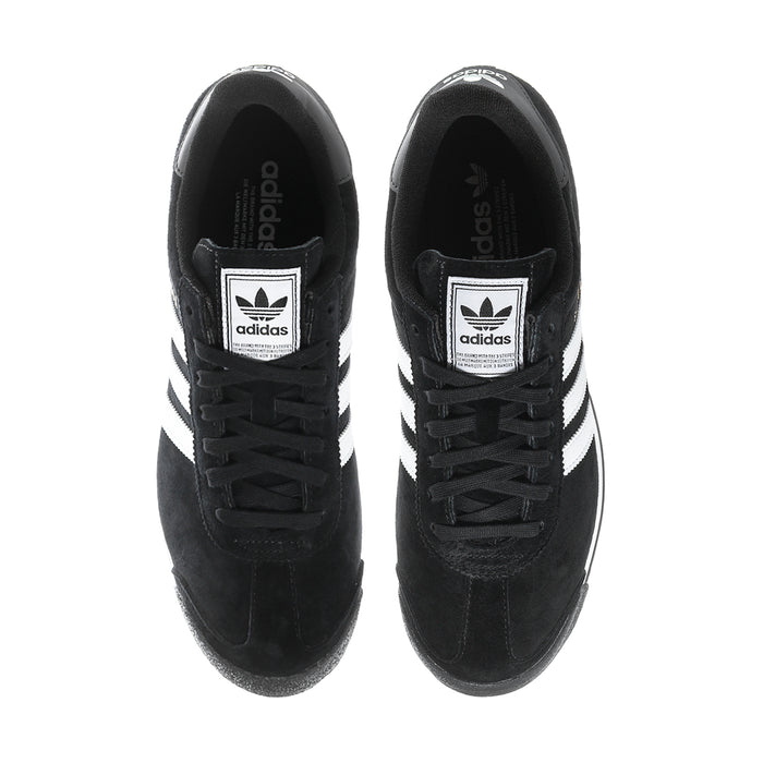 Black suede sneakers showing tongue adidas logo patches and white side stripes