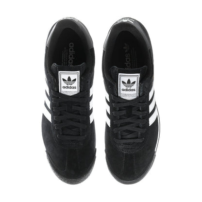 Black suede sneakers showing tongue adidas logo patches and white side stripes