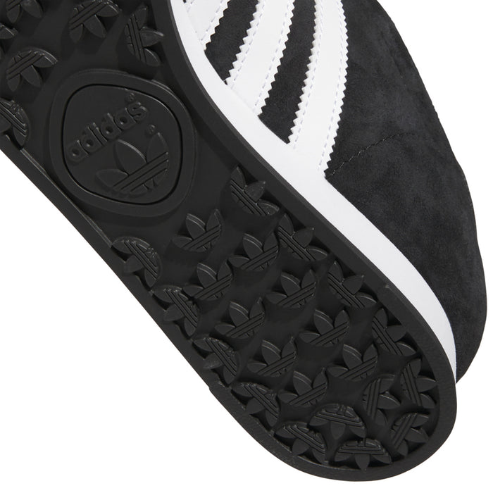 Close-up of black textured outsole pattern with adidas logo and white midsole edge