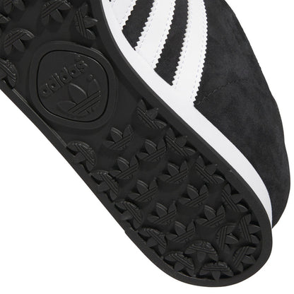 Close-up of black textured outsole pattern with adidas logo and white midsole edge