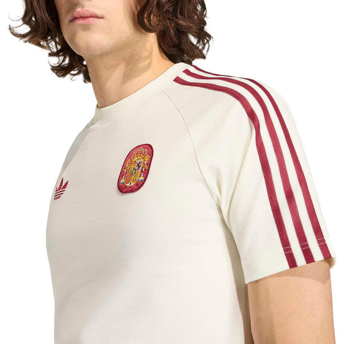 Off-white T-shirt close-up: Spain crest patch and maroon three-stripe sleeves.