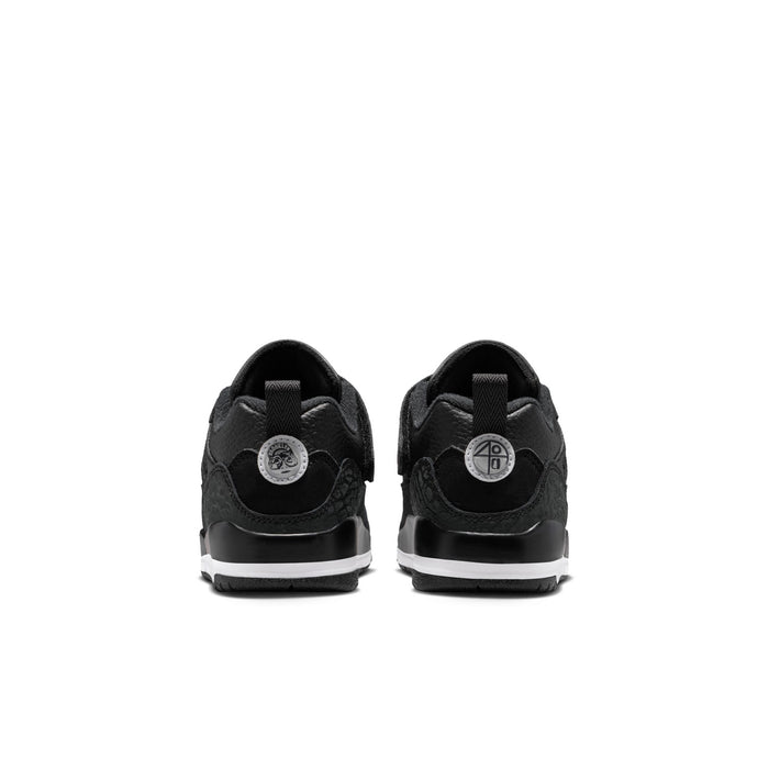 Kids black low-top sneakers with heel tab, circular back logo patch, white midsole
