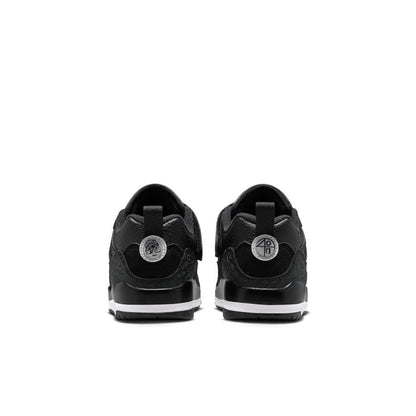 Kids black low-top sneakers with heel tab, circular back logo patch, white midsole