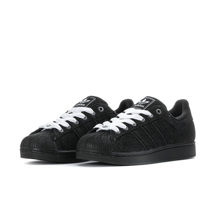Pair of black low-top sneakers with white lace-up details and black rubber sole