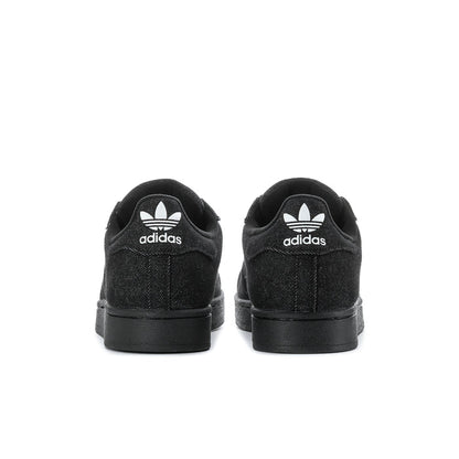 Black low-top sneakers with rear adidas logo and black rubber heel sole