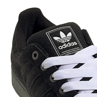 Close-up of black adidas sneakers with white laces and tongue badge logo