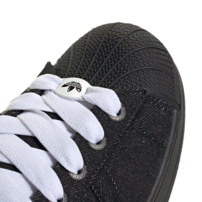 Close-up of black sneaker side with white laces and textured fabric upper
