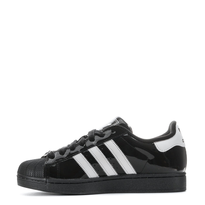 Youth low-top sneakers with white side stripes, black glossy upper, and lace-up