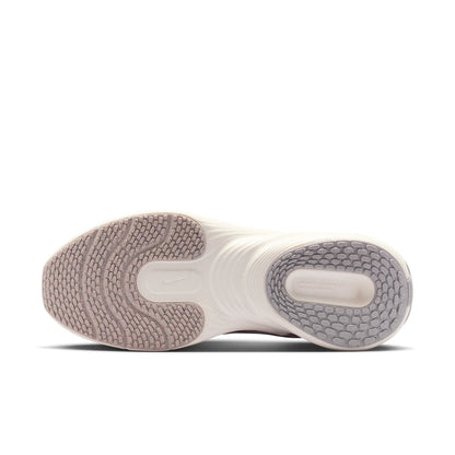 Bottom view of mauve-and-white sneakers with textured rubber outsole and cushioning