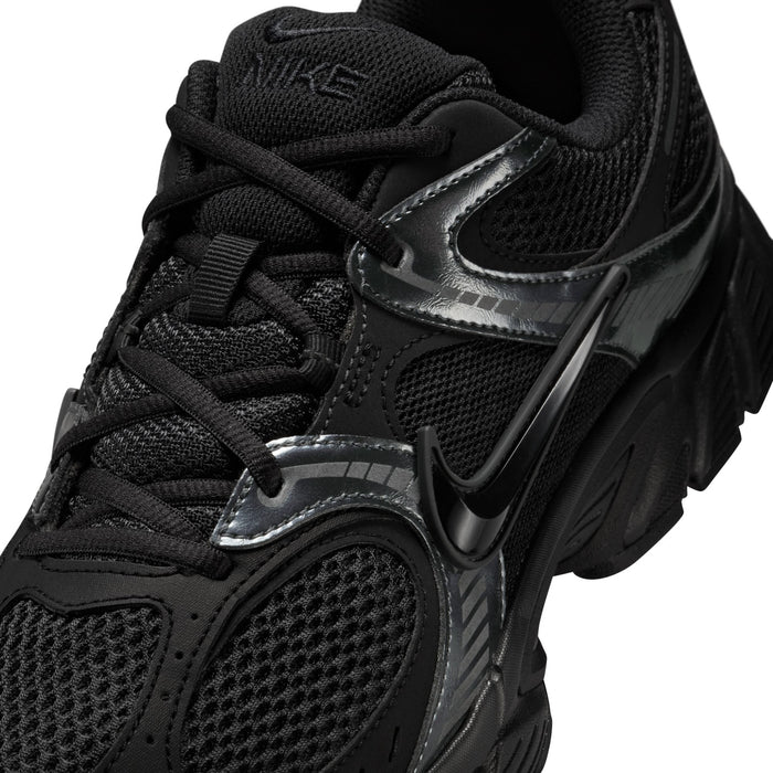 Men's black sneaker close-up with black laces, silver trim, and Nike Swoosh