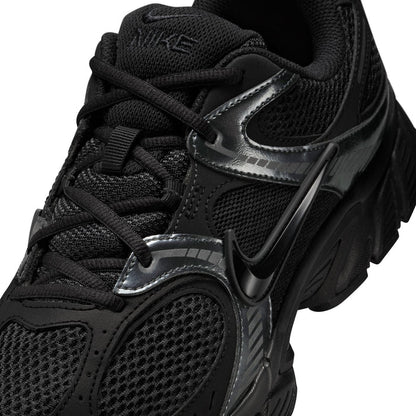 Men's black sneaker close-up with black laces, silver trim, and Nike Swoosh