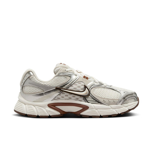 White and light-brown Nike running sneakers, side profile with swoosh and cushioned sole.