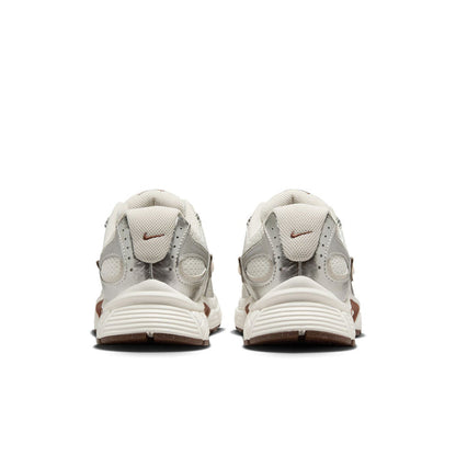 White Nike sneakers, rear view with heel tab and cushioned sole details.