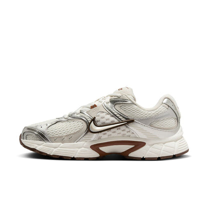 White Nike running sneakers, angled side view with swoosh and brown panel accents.