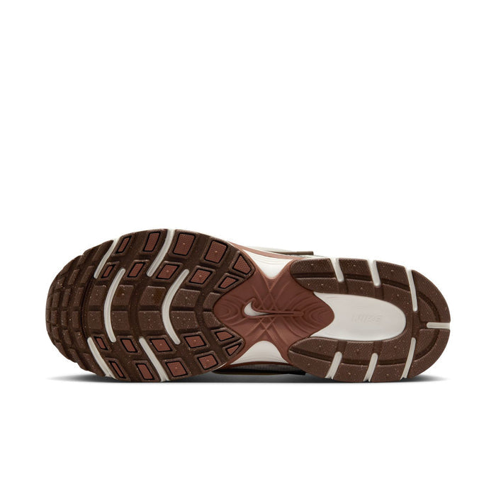 Outsole view of white Nike sneakers with brown rubber tread pattern.