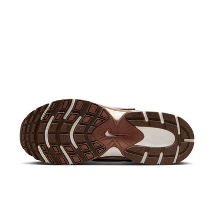 Outsole view of white Nike sneakers with brown rubber tread pattern.