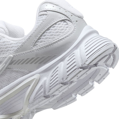 Close-up of white sneaker side with mesh paneling, lace eyelets, and outsole tread