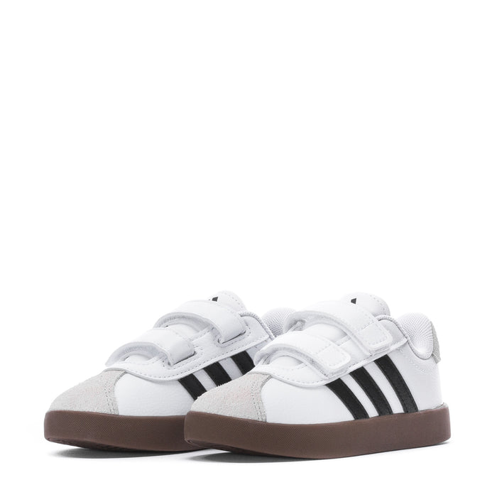 Pair of white toddler sneakers with two black stripes and Velcro straps, brown sole
