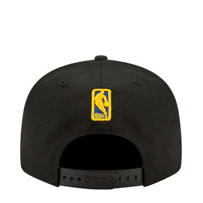 Black baseball cap with yellow on-back badge and ventilated panel holes