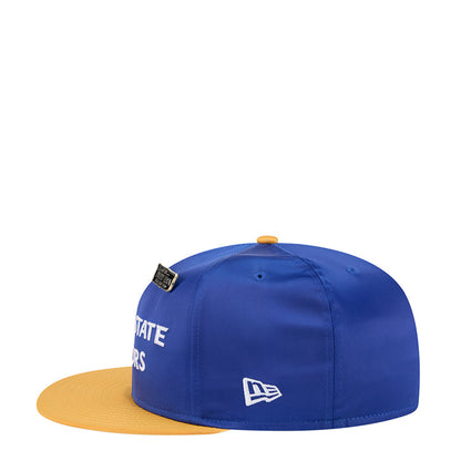 Blue satin baseball cap with yellow brim, black side tag and New Era emblem