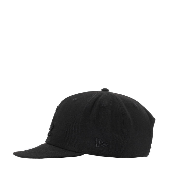 Black baseball cap with small embroidered emblem and curved brim