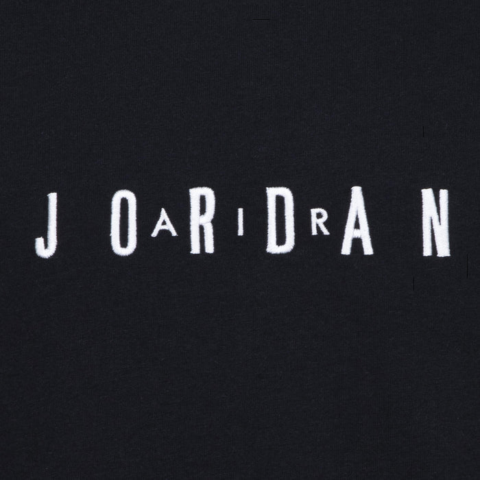 Close-up of embroidered JORDAN wordmark on youth black T-shirt chest